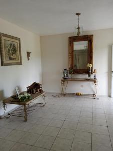 Habitación con mesa y espejo en la pared. en Heidy House, en Arecibo