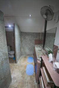 y baño con aseo, lavabo y espejo. en Bangka Hostels, en El Nido