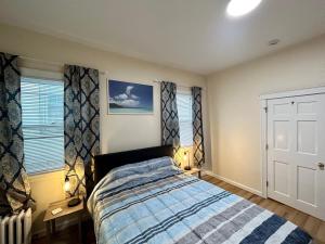 a bedroom with a bed and two windows at Cozy Boston Apartment in Medford
