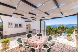 a dining room with a table and chairs on a balcony at Apartmani Katica in Povile