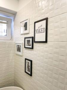 ein Badezimmer mit gerahmten Bildern an der Wand in der Unterkunft Apartment *MALA* in Žalec