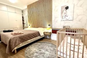 a bedroom with a bed and a crib in it at Loft entre Paris et Disney in Le Perreux-Sur-Marne