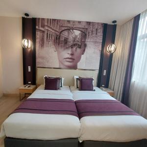 2 camas en una habitación de hotel con una gran foto en la pared en BEYZAA HOTEL AND SUITES, en Calcuta