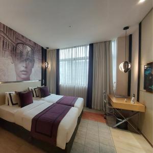 Habitación de hotel con cama grande y escritorio. en BEYZAA HOTEL AND SUITES, en Calcuta