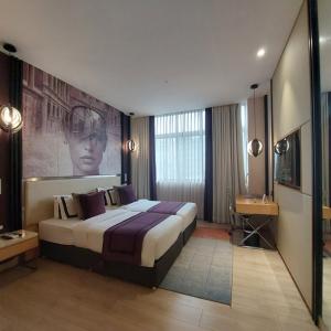 Habitación de hotel con cama grande y escritorio. en BEYZAA HOTEL AND SUITES, en Calcuta