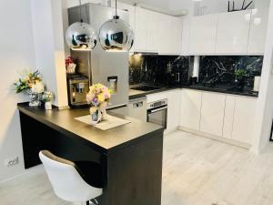 a kitchen with white cabinets and a counter with flowers on it at Aici te simți ca acasa 2 in Iaşi