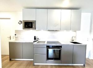 uma cozinha com electrodomésticos de aço inoxidável e armários brancos em 3 Pièces, Standing, Centre, 2 Sdb, 2 WC, Balcon em Deauville