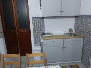 a small kitchen with a sink and two chairs at Quintinha de Santiago in Oliveira de Azemeis
