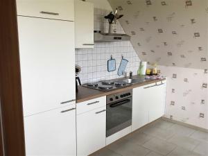 a kitchen with white cabinets and a stove at Ferienwohnung Mangelsen in Gelting