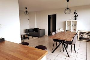 沙勒羅瓦的住宿－Airport Access Apartment - Your Gateway to Comfort，客厅配有木桌和椅子