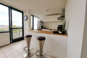 a kitchen with two stools in front of a counter at Airport Access Apartment - Your Gateway to Comfort in Charleroi