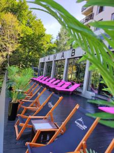 a row of lounge chairs sitting on a patio at L&N Apartmani Kopaonik-Milmari Resort in Kopaonik