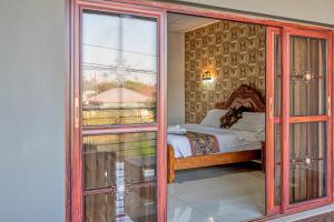 um quarto com uma cama e uma porta de vidro em The Crest Lodge Limited em Lusaka