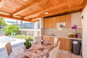 a kitchen and dining room with a table and chairs at Apartmani Katica in Povile