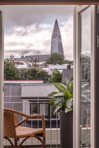 einen Balkon mit einem Stuhl und Blick auf ein Gebäude in der Unterkunft Hotel Von in Reykjavík