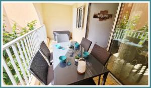 einen Tisch und Stühle auf einem Balkon mit einem Tisch in der Unterkunft Bel Appartement cap dagde in Cap d'Agde