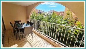 einen Balkon mit einem Tisch und Stühlen sowie einem Fenster in der Unterkunft Bel Appartement cap dagde in Cap d'Agde