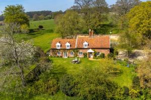 una vista aérea de una casa en un campo en Keepers Cottage by Big Skies Cottages en Itteringham