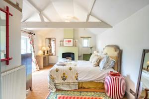 1 dormitorio con 1 cama y chimenea en Keepers Cottage by Big Skies Cottages en Itteringham