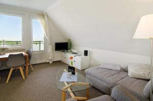 a living room with a couch and a table at Strandhus Uiterst-hörn Utkiek in Baltrum