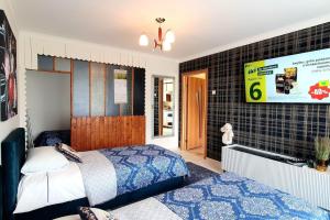a bedroom with a bed and a tv on a wall at Studio apartment in Joniškis in Joniškis