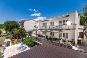 a large deck with chairs on top of a house at Apartmani Katica in Povile
