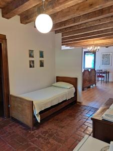 1 dormitorio con 1 cama en una habitación con techos de madera en Corte Ramedello, en Cerea