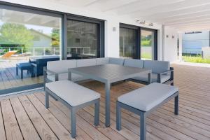 einen Tisch und zwei Hocker auf einer Terrasse in der Unterkunft Seesehnsucht Höri in Gaienhofen