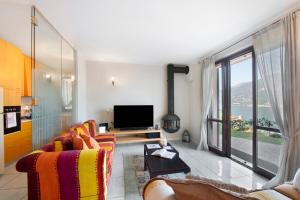 een woonkamer met een bank en een tv bij Casa Marina Bellagio private garden in Bellagio