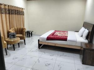 a bedroom with a bed and a chair and a table at Unique Heights in Murree