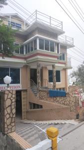 a building with a yellow fire hydrant in front of it at Unique Heights in Murree