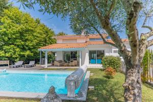 uma casa com piscina e uma casa em Villa St Martin em Pompignac