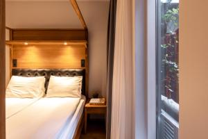 a bed with a wooden headboard next to a window at Hotel Von in Reykjavík
