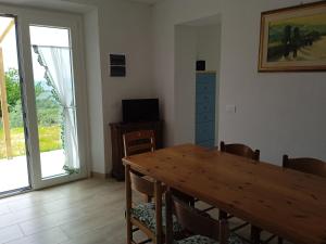 comedor con mesa de madera y puerta corredera de cristal en Casa vacanze in pietra Il Nibbio Reale, en Semproniano