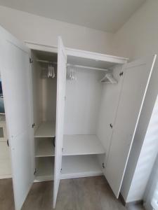 a white walk in closet with white cabinets at Las Vegas Apartment in Paderborn