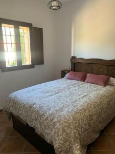 ein Schlafzimmer mit einem Bett mit zwei Kissen darauf in der Unterkunft Cortijo Los Pinillos in Pinos Genil + 42 Fotos