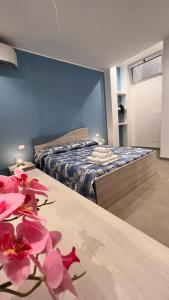 a bedroom with a bed and pink flowers on a table at Case vacanze Cappero e Malvasia in Canneto