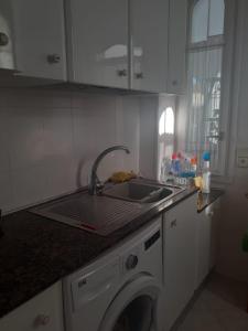 eine Küche mit einer Spüle und einer Waschmaschine in der Unterkunft Trinidad in Vinarós