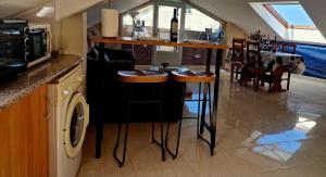 a bar with stools in a kitchen with a table at RINCON DO MAR ATC DH in A Guarda