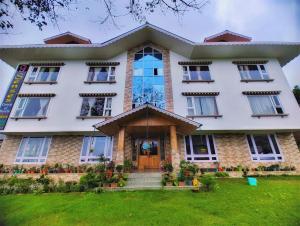 a large white building with a front door at 9 Senses Group hotels , Ravangla in Ravangla