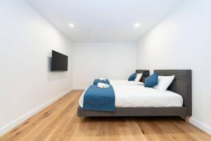 a bedroom with a bed and a television on a wall at Calming Urban Oasis in Melbourne