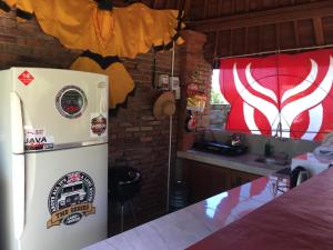 a kitchen with a refrigerator with stickers on it at Kubu Pering in Keramas