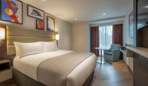 Un pat sau paturi într-o cameră la Maldron Hotel Finsbury Park, London