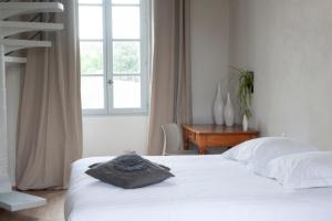 Schlafzimmer mit einem Bett, einem Schreibtisch und einem Fenster in der Unterkunft Domaine de la Bedosse in Alès