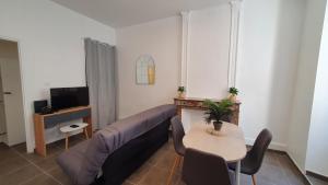uma sala de estar com um sofá e uma mesa em Le cœur Montilien em Montélimar
