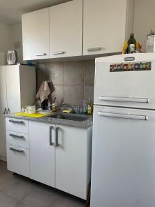 a kitchen with white cabinets and a white refrigerator at Departamento Leguizamón in Godoy Cruz