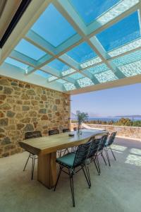 a large wooden table and chairs in a room with a glass ceiling at Luxusvilla Pylos 6 Personen privater Pool in Gialova
