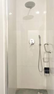 La salle de bains est pourvue d'une douche avec une porte en verre. dans l'établissement SJ2E Heart of Baixa NEW AIR CONDITIONING Spacious and Lovely, à Lisbonne
