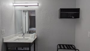 a bathroom with a sink and a mirror and a chair at Motel 6-Nashua, NH in Nashua