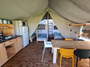 a kitchen and dining area of a tent with a table and chairs at Luxe kamperen bij Procamp4all in Holten